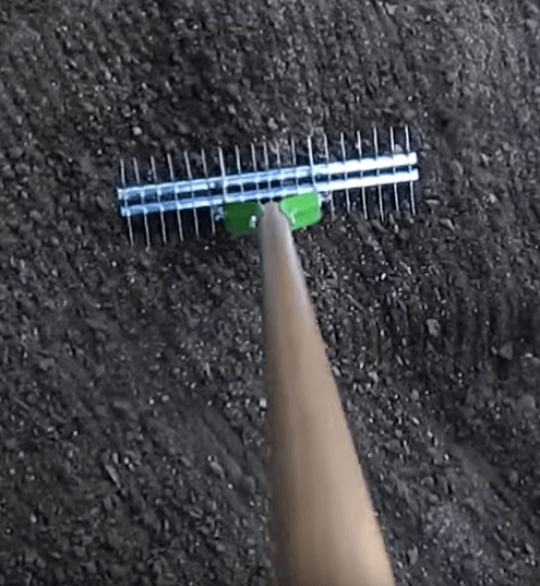 Overhead shot of a thatch rake in soil