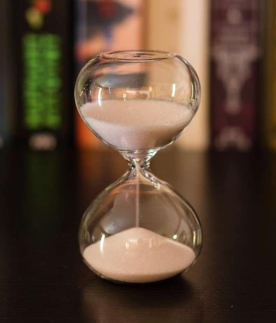 Hourglass with blurry books in background