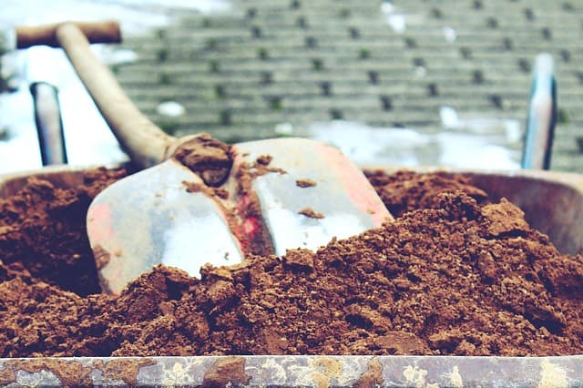 closeup of soil and a shovel in a wheelbarrow