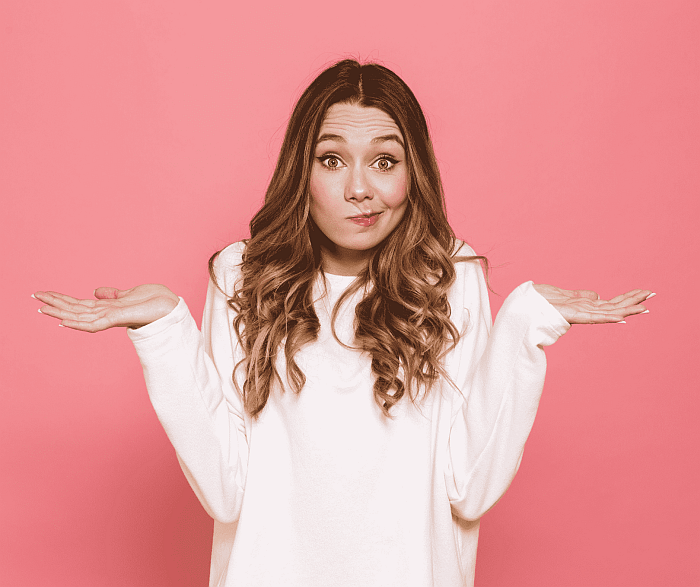 young woman shrugging her shoulders in confusion